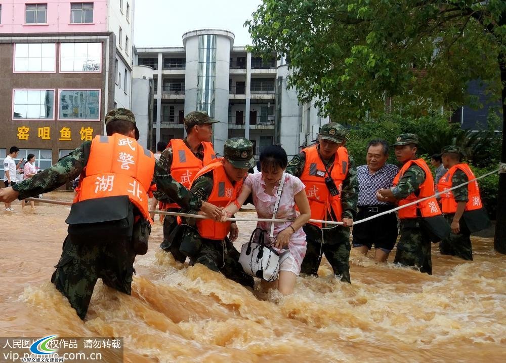 8月13日，武警湖北省总队咸宁支队官兵在咸宁城区转移受灾群众。