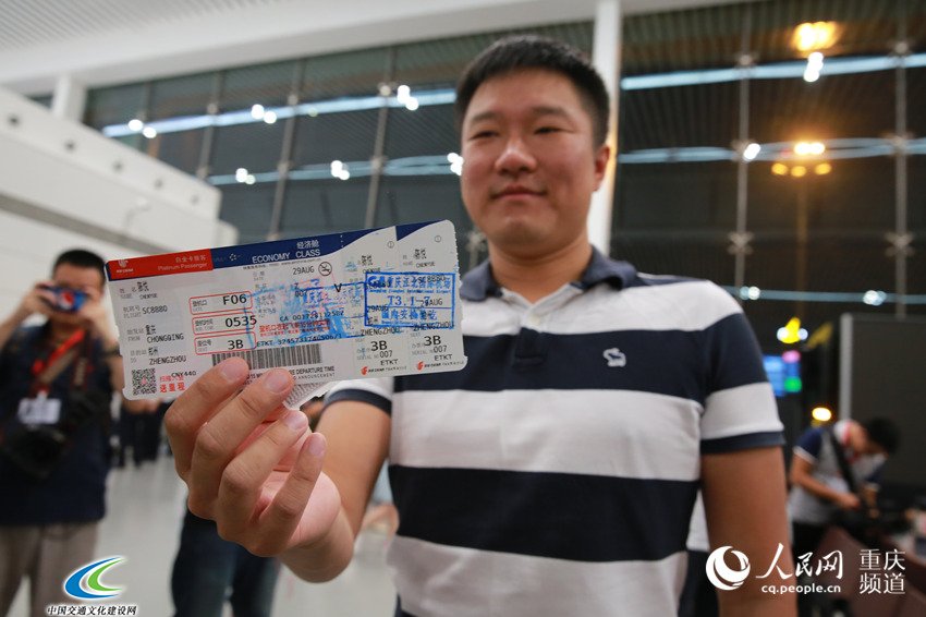 T3A航站楼首飞航班的首位购票旅客向记者展示机票。刘政宁 摄